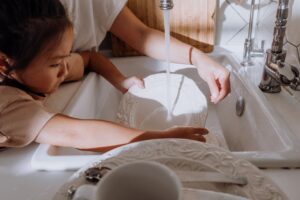 Little girl washing hands in sink, ABA therapy