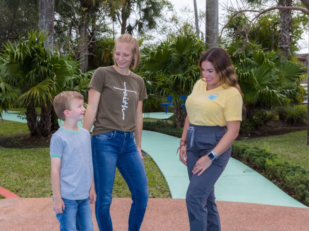 Metamorphosis ABA therapist talking with a mother and her young son outdoors