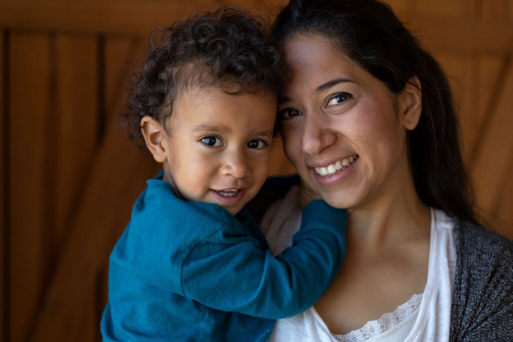 Smiling mother holding her young son at home