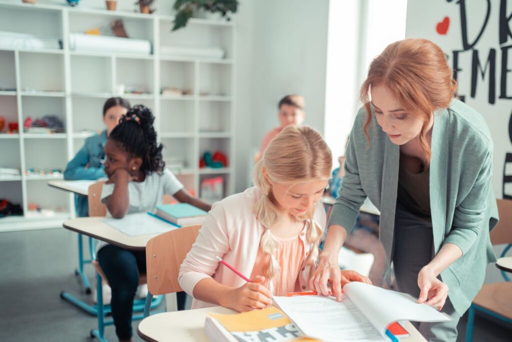 Teacher giving one-to-one support to a student in a classroom